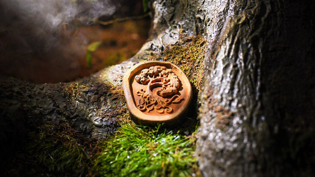 Houten amulet met boommotief op mos in de escape room